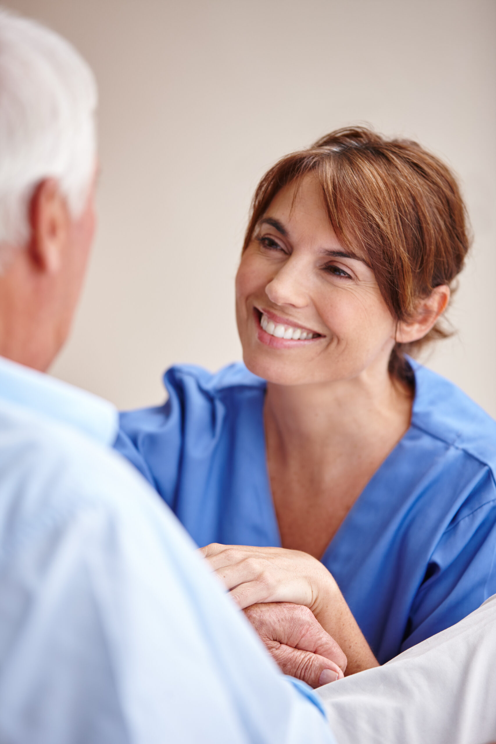 Happy nurse, holding hands and senior man with support, homecare or empathy with woman. Caregiver, comfort or elderly person with medical wellness, healthcare or smile for kindness in retirement home