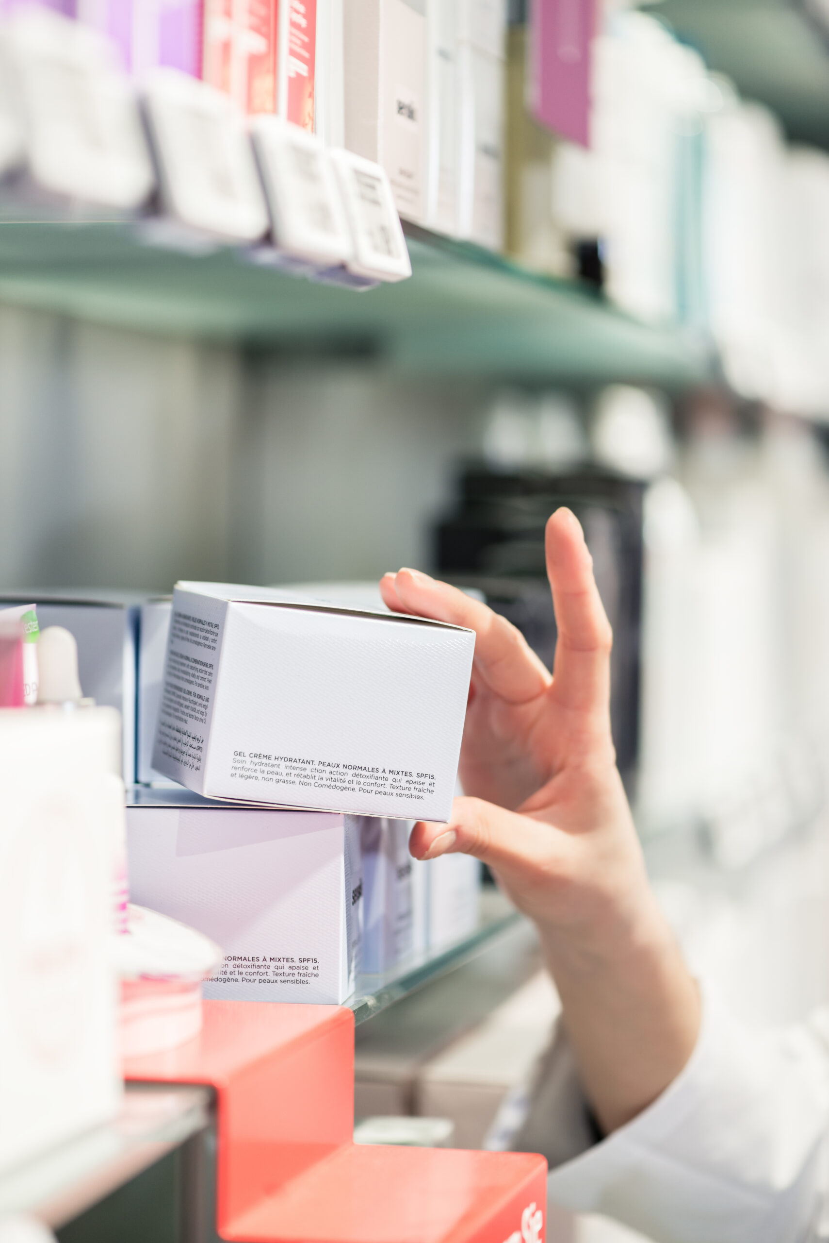 Close-up of the hand of female pharmacist picking up the best product